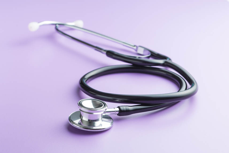 Black medical stethoscope on purple background. Stethoscope for listening to the heart.
